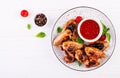 Baked chicken wings in the Asian style and tomatoes sauce on plate. Royalty Free Stock Photo