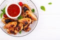 Baked chicken wings in the Asian style and tomatoes sauce on plate. Royalty Free Stock Photo