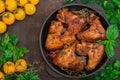 Baked chicken wings in baking pan. Selective focus. Wooden background. Close-up. Top view Royalty Free Stock Photo