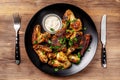 Baked chicken wings in Mexican with curry seasoning and parsley on a black plate, on a wooden background. side view, copy space Royalty Free Stock Photo