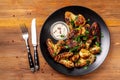 Baked chicken wings in Mexican with curry seasoning and parsley on a black plate, on a wooden background. side view, copy space Royalty Free Stock Photo