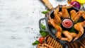 Baked chicken wings in a pan with ketchup and onions. Barbecue. Top view. Royalty Free Stock Photo