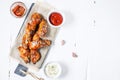 Baked chicken wings with sauce on white wood background . Copy space. Royalty Free Stock Photo