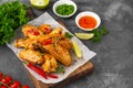 Baked chicken wings served with sweet chili sauce and fresh herbs. Selective focus Royalty Free Stock Photo