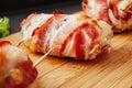 Baked chicken wrapped in bacon. Delicious appetizer with crispy smoked bacon. Chicken breast wrapped in bacon on wooden board. Royalty Free Stock Photo