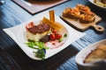 Baked Cod fish with sauce, pan grilled baby vegetables, pea and tomato served with bread sticks Royalty Free Stock Photo