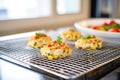 baked crab cakes cooling on a wire rack, kitchen setting