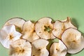 Baked Dehydrated dried Apples Chips over green background with copy space