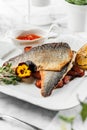 Baked Dorado fillet fish with sweet potato, lime and tomato sauce at the white plate on light marble background. Healthy sea food Royalty Free Stock Photo