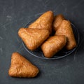 Baked dough triangles on a gray background. Fresh pastries food for breakfast concept. Square format or 1x1 for posting