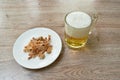 Baked dry salty squid slice on plate eat couple with cold beer on table