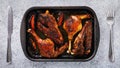 Baked duck with grilled oranges in a baking tray on the table