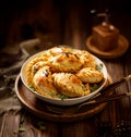 Baked dumplings pierogi with mushroom stuffing in a ceramic bowl on a wooden table