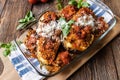 Baked eggplant with brown rice, tuna, tomato sauce and parmesan cheese on wooden background