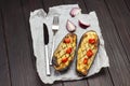 Baked eggplant with onions and tomatoes, knife and fork on paper