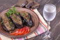 Baked eggplant stuffed with onions, cherry plums, walnuts on the plate and a glass of cold vodka Royalty Free Stock Photo