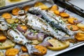 Baked Fish Bluefish with Sweet Potatoes on Oven Tray with Baking Paper Sheet / Lufer