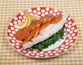 Baked fish fillet with rainbow trout with stewed vegetables and boiled spinach, and with a slice of lemon Royalty Free Stock Photo