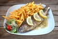 Baked fish - trout, salad and french fries on plate