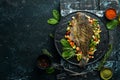 Baked Flounder Fish with Vegetables on a Black Stone Plate. Seafood. Top view.