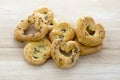 Baked fresh pretzels on wooden table, heart and twisted knot shapes, covered with poppy seeds salt and caraway seeds