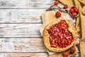 Baked galette with strawberry and rhubarb, pie on the table. Homemade pastry. White background. Top view. Copy space Royalty Free Stock Photo