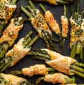 Baked green asparagus in puff pastry sprinkled with sesame seeds, nigella seeds and fresh thyme on a black background, close-up, t Royalty Free Stock Photo