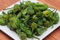 Baked green peppers with crystals of salt. Portion of fresh made Pimientos de Padron. Traditional spanish snack.