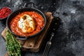 Baked hake white fish with tomato in a pan. Black background. Top view. Copy space Royalty Free Stock Photo