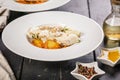 Baked halibut fillet with vegetables and confit potatoes in a white plate. Restaurant recipes. Delicious natural seafood. Pepper,