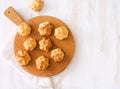 Baked homemade profiteroles on wooden cutting board