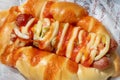 Baked hot dog served with pepperoni and sauces