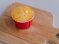 Baked Japanese cheese cup in red paper cup on wooden board. sweet tasty dessert. cheese tart cake Royalty Free Stock Photo