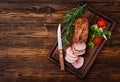 Baked juicy veal fillet in spices on a wooden table. Medium Well.