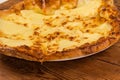 Baked khachapuri on dish on rustic table, close-up