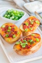 Baked loaded potato skins with cheddar cheese and bacon on ceramic plate, garnished with scallions and sour cream, vertical Royalty Free Stock Photo