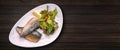 Baked mackerel fillet with salad and mushrooms, on a plate, on a wooden background Royalty Free Stock Photo