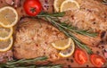 Baked mackerel with slices of lemon, rosemary, tomatoes, garlic, salt, red and black pepper on wooden cutting board. Top view, Royalty Free Stock Photo