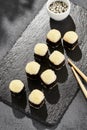 Baked Maki sushi on dark slate. Hot cheese hosomaki roll. Simple sushi roll with cheese, baked cheese topped. Style concept