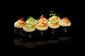 Baked maki sushi rolls with cheese cap on black background