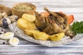 Baked meat quail with potatoes and spices on a plate