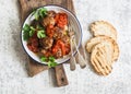 Baked meatballs with tomato sauce and herbs on a wooden cutting Board on white background. Top view.