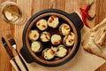 Baked mushrooms caps stuffed with sulguni in wooden bowl