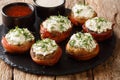 Baked mushrooms with cream cheese wrapped in bacon served with sauces close-up on the table. horizontal Royalty Free Stock Photo