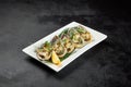 Baked mussels with cheese on plate on dark concrete background. Appetizer of mussels and lemon in minimal style on black table. Royalty Free Stock Photo