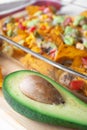 Baked nacho dish in a glass baking pan with corn tortilla chip, pico de gallo salsa, avocado guacamole chipotle, beans, jalapenos Royalty Free Stock Photo