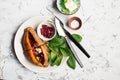 Baked in the oven sweet potatoes with butter, salt, cilantro and pomegranate seeds on a plate with a garnish of fresh Royalty Free Stock Photo