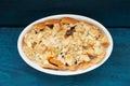 Baked panettone pudding in oval baking dish on navy blue background