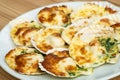 Baked parmesan scallops in a white ceramic plate on a wooden table . Oven baked scallop with cheese, spinach, butter and garlic Royalty Free Stock Photo
