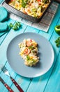 Baked pasta with broccoli and cheesy tomato sauce on blue wood background. Royalty Free Stock Photo